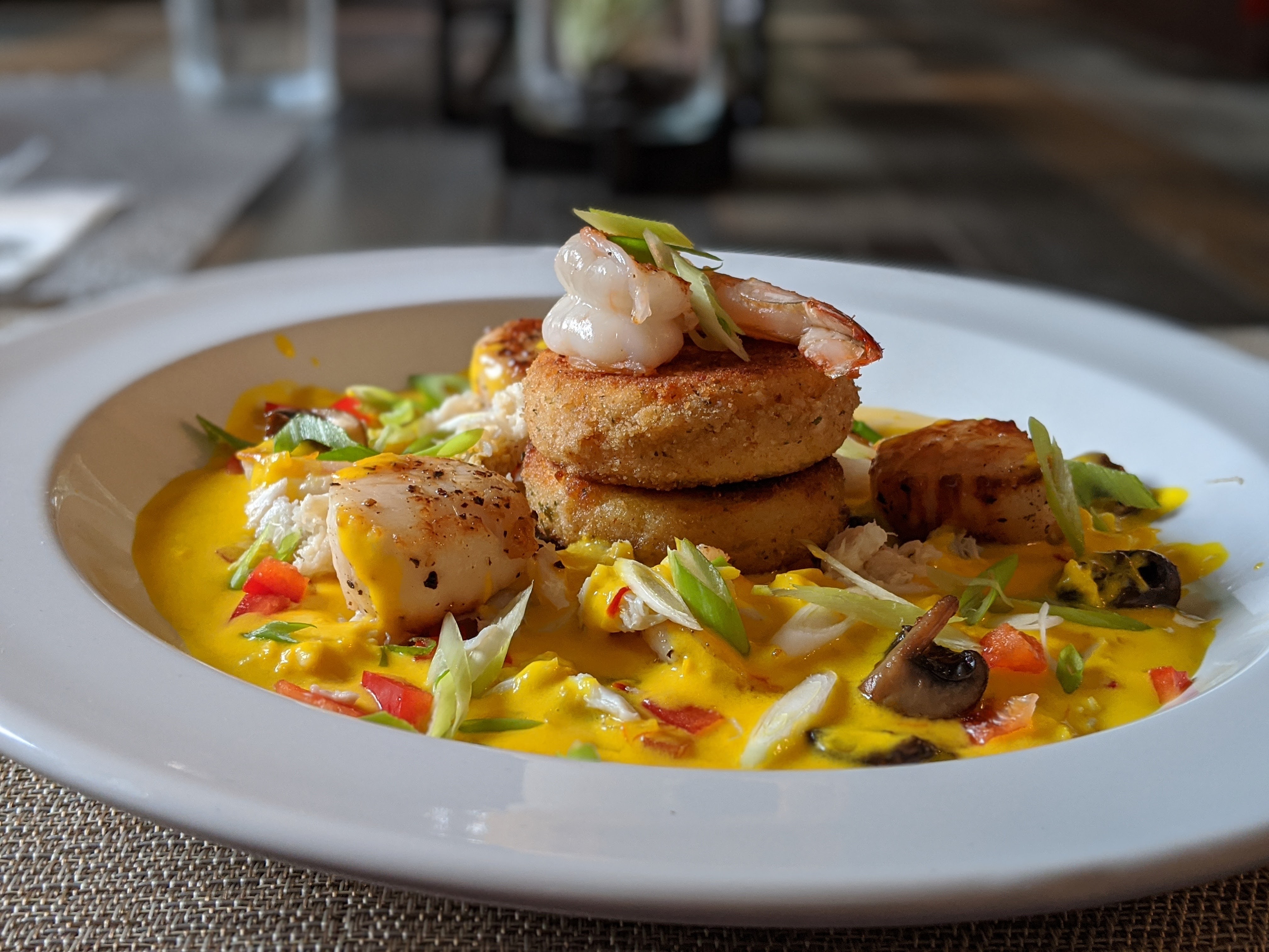 Scallops, Shrimp, Polenta Cakes with Shellfish Saffron Cream Sauce from the side