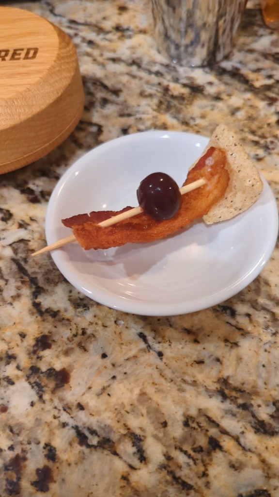 Garnish with Bacon, Cherry and Pork Rinds.