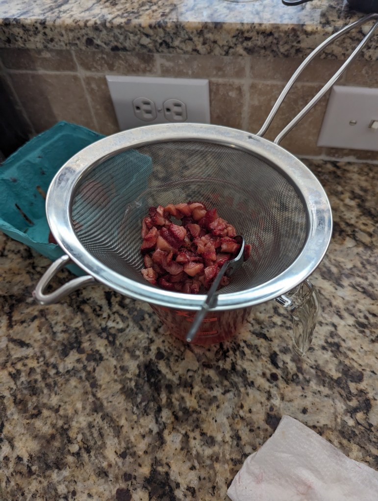 Macerated Strawberries being strained.