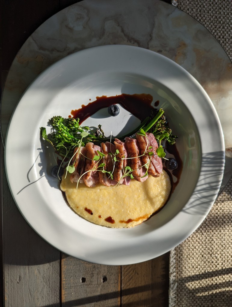 Sous Vide Duck Breast, Gruyère Grits, Duck Fat Charred Broccolini with a Bourbon, Blueberry Balsamic Reduction - Top Vert