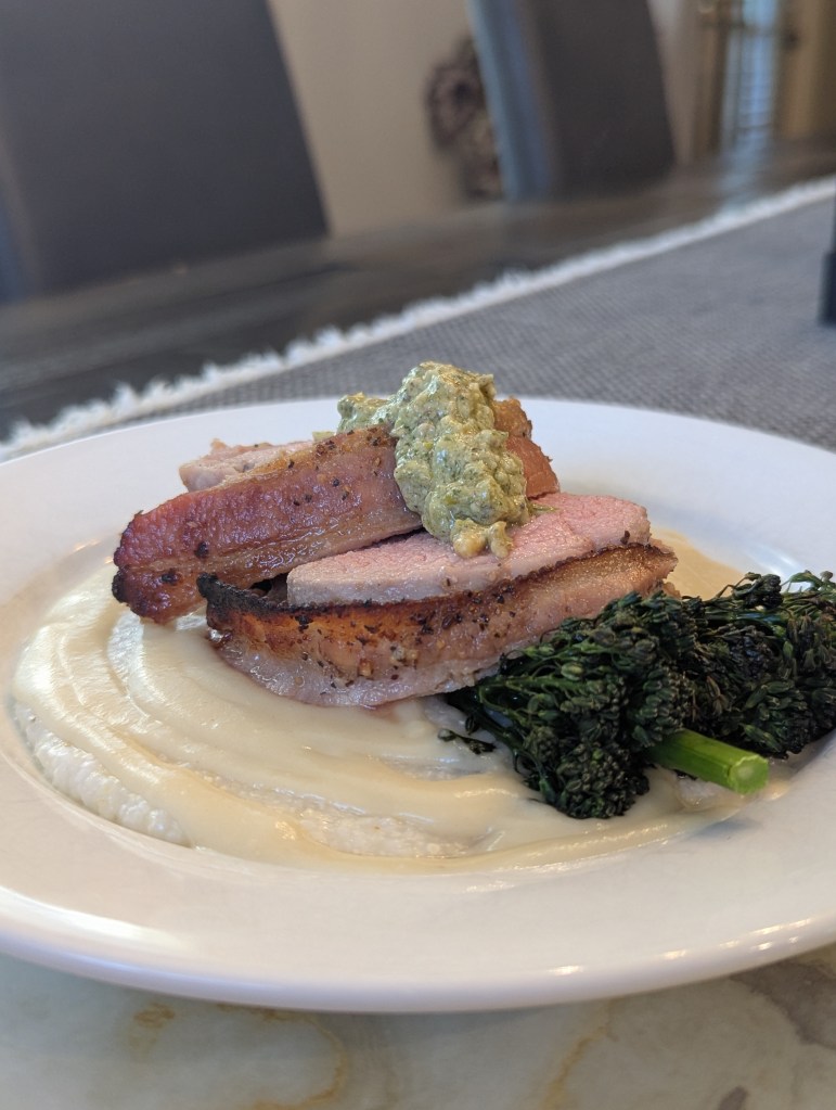 Sous Vide Bacon Wrapped Pork Tenderloin, Grits, Broccolini, Habanero Cream with Charred Scallion and Almond Pesto - Portrait